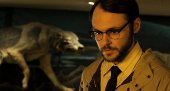 Movie still from “Sound of My Voice” (2011), directed by Zal Batmanglij – A man in a suit and tie next to an animal; Close Up shot, Low angle
