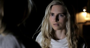 Movie still from “Sound of My Voice” (2011), directed by Zal Batmanglij – A woman with long blonde hair looking at the camera; Close Up shot, Over the shoulder angle