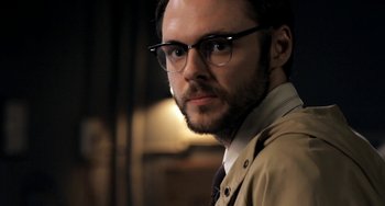 Movie still from “Sound of My Voice” (2011), directed by Zal Batmanglij – A person wearing glasses and a tie; Close Up shot, Over the shoulder angle