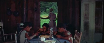 Movie still from “Sounder” (1972), directed by Martin Ritt – A group of people sitting at a table eating food; Medium shot, High angle