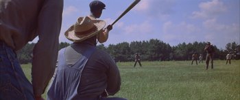 Movie still from “Sounder” (1972), directed by Martin Ritt – Two men are playing baseball in a grassy field; Wide shot, Over the shoulder angle