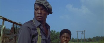 Movie still from “Sounder” (1972), directed by Martin Ritt – Two black men standing next to each other in a field; Close Up shot, Low angle