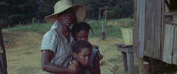 Movie still from “Sounder” (1972), directed by Martin Ritt – A woman and two children are standing in a field; Medium shot, High angle