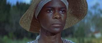 Movie still from “Sounder” (1972), directed by Martin Ritt – A person wearing a straw hat; Close Up shot, Low angle
