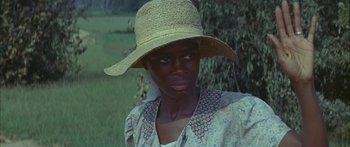 Movie still from “Sounder” (1972), directed by Martin Ritt – A woman wearing a hat standing next to a tree; Close Up shot, High angle