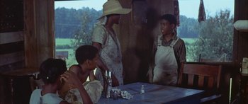 Movie still from “Sounder” (1972), directed by Martin Ritt – A group of people sitting around a table; Medium shot, Over the shoulder angle