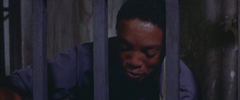 Movie still from “Sounder” (1972), directed by Martin Ritt – A man in a jail cell looking through the bars; Close Up shot, High angle