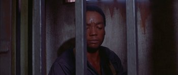 Movie still from “Sounder” (1972), directed by Martin Ritt – A man sitting in front of a window in a jail cell; Close Up shot, High angle