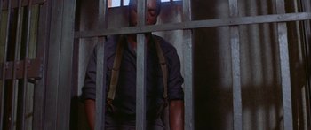 Movie still from “Sounder” (1972), directed by Martin Ritt – A man standing behind bars in a jail cell; Medium shot, High angle