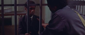 Movie still from “Sounder” (1972), directed by Martin Ritt – A man in a suit and tie looking at himself in a mirror; Medium shot, Over the shoulder angle