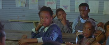 Movie still from “Sounder” (1972), directed by Martin Ritt – A girl and a boy sitting at a table in a classroom; Medium shot, Over the shoulder angle