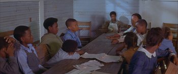 Movie still from “Sounder” (1972), directed by Martin Ritt – A group of people sitting around a table; Medium shot, Over the shoulder angle