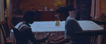 Movie still from “Sounder” (1972), directed by Martin Ritt – Two young men sitting at a table with a banana peel; Medium shot, High angle