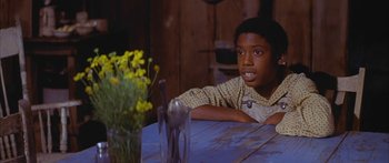 Movie still from “Sounder” (1972), directed by Martin Ritt – A boy sitting at a table with a knife in his hand; Close Up shot, Over the shoulder angle