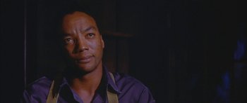 Movie still from “Sounder” (1972), directed by Martin Ritt – A person wearing a purple shirt; Close Up shot, Low angle