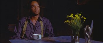 Movie still from “Sounder” (1972), directed by Martin Ritt – A man sitting at a table with a cup of coffee; Medium shot, Low angle