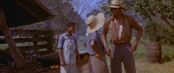 Movie still from “Sounder” (1972), directed by Martin Ritt – A group of men standing next to each other near a fire pit; Medium shot, Low angle
