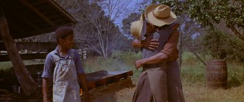 Movie still from “Sounder” (1972), directed by Martin Ritt – A group of people standing next to an open fire pit; Medium shot, Low angle