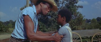 Movie still from “Sounder” (1972), directed by Martin Ritt – A man and a boy are holding each other; Medium shot, Low angle