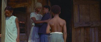 Movie still from “Sounder” (1972), directed by Martin Ritt – A woman and two boys standing next to each other; Medium shot, Over the shoulder angle