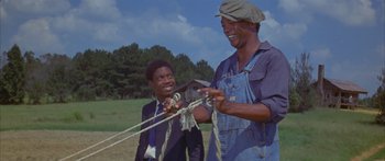 Movie still from “Sounder” (1972), directed by Martin Ritt – Two men in suits and hats are holding ropes; Medium shot, Low angle