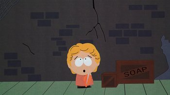 Movie still from “South Park: Bigger, Longer & Uncut” (1999), directed by Trey Parker – A south park character is standing in front of a brick wall; Wide shot, High angle