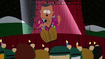 Movie still from “South Park: Bigger, Longer & Uncut” (1999), directed by Trey Parker – A cartoon of a man standing in front of a crowd; Medium shot, High angle