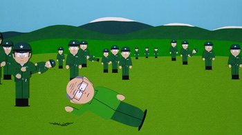 Movie still from “South Park: Bigger, Longer & Uncut” (1999), directed by Trey Parker – A cartoon of a man in a green shirt surrounded by army men; Wide shot, Overhead angle