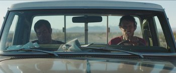 Movie still from “Southbound” (2015), directed by Tyler Gillett – Two men sitting in the back seat of a car looking out the window; Medium shot, Low angle