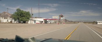 Movie still from “Southbound” (2015), directed by Tyler Gillett – An empty road in front of an old diner; Extreme Wide shot, High angle