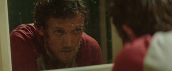Movie still from “Southbound” (2015), directed by Tyler Gillett – A person in a bathroom mirror; Close Up shot, Over the shoulder angle