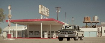 Movie still from “Southbound” (2015), directed by Tyler Gillett – A truck driving down a street past a diner; Extreme Wide shot, Low angle