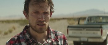 Movie still from “Southbound” (2015), directed by Tyler Gillett – A person wearing a plaid shirt; Close Up shot, Over the shoulder angle