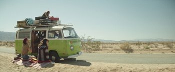 Movie still from “Southbound” (2015), directed by Tyler Gillett – A green van is parked on the side of the road; Wide shot, Low angle