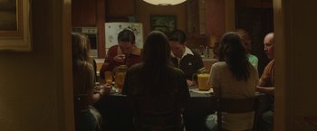 Movie still from “Southbound” (2015), directed by Tyler Gillett – A group of people sitting at a table eating food; Medium shot, High angle