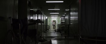 Movie still from “Southbound” (2015), directed by Tyler Gillett – Two people are walking down a hallway in a building; Extreme Wide shot, Low angle