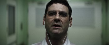 Movie still from “Southbound” (2015), directed by Tyler Gillett – A person wearing glasses and headphones; Close Up shot, Low angle