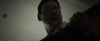 Movie still from “Southbound” (2015), directed by Tyler Gillett – A person wearing glasses and a white shirt; Close Up shot, Low angle
