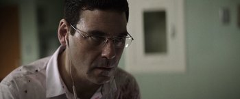 Movie still from “Southbound” (2015), directed by Tyler Gillett – A person wearing glasses and listening to music; Close Up shot, Over the shoulder angle