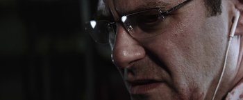 Movie still from “Southbound” (2015), directed by Tyler Gillett – A person wearing glasses; Extreme Close Up shot, Low angle