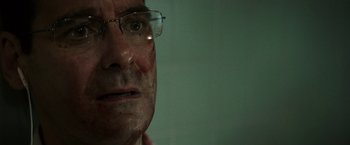 Movie still from “Southbound” (2015), directed by Tyler Gillett – An older man wearing glasses looking at the camera; Close Up shot, Over the shoulder angle