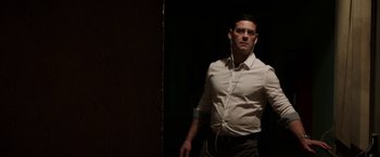 Movie still from “Southbound” (2015), directed by Tyler Gillett – A man in a white dress shirt is listening to music; Medium shot, Low angle