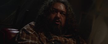 Movie still from “Southbound” (2015), directed by Tyler Gillett – A person wearing a plaid shirt; Close Up shot, Over the shoulder angle