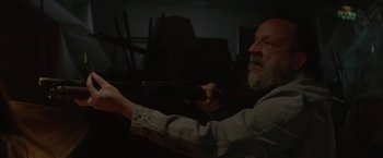 Movie still from “Southbound” (2015), directed by Tyler Gillett – An older man is holding a remote in his hand; Close Up shot, Over the shoulder angle