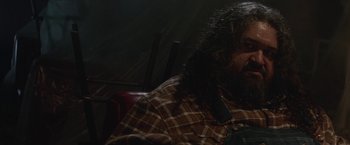 Movie still from “Southbound” (2015), directed by Tyler Gillett – A man with long hair sitting in front of a window; Close Up shot, High angle