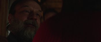 Movie still from “Southbound” (2015), directed by Tyler Gillett – A man with a gray beard is looking at the camera; Close Up shot, Over the shoulder angle