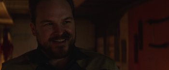 Movie still from “Southbound” (2015), directed by Tyler Gillett – A person smiling at the camera; Close Up shot, Over the shoulder angle