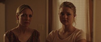 Movie still from “Southbound” (2015), directed by Tyler Gillett – Two women standing next to each other in front of a window; Close Up shot, Over the shoulder angle