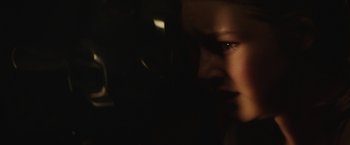 Movie still from “Southbound” (2015), directed by Tyler Gillett – A young woman with dark eyes looking into the distance; Extreme Close Up shot, Over the shoulder angle