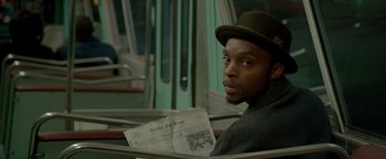 Movie still from “Sparkle” (2012), directed by Salim Akil – A man sitting on a bus reading a newspaper; Close Up shot, Over the shoulder angle